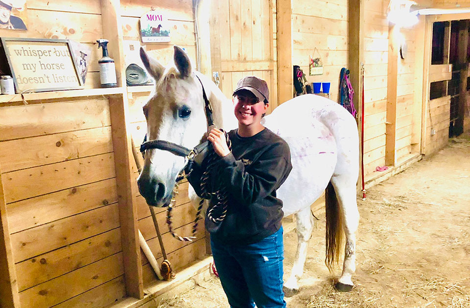 Jessie with horse in barn