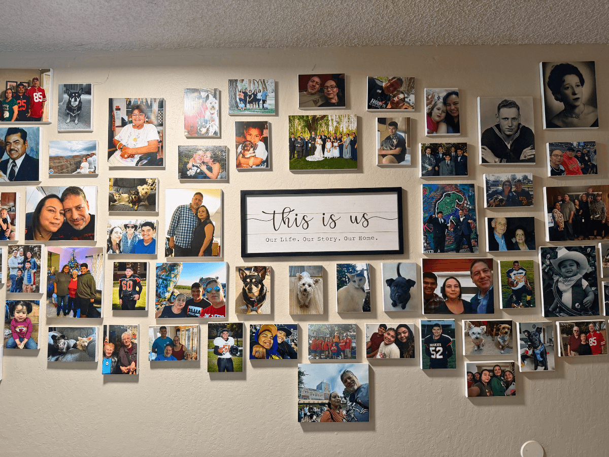 Wall collage of numerous family photos around a centered framed sign reading 'this is us' (Our Life. Our Story. Our Home).